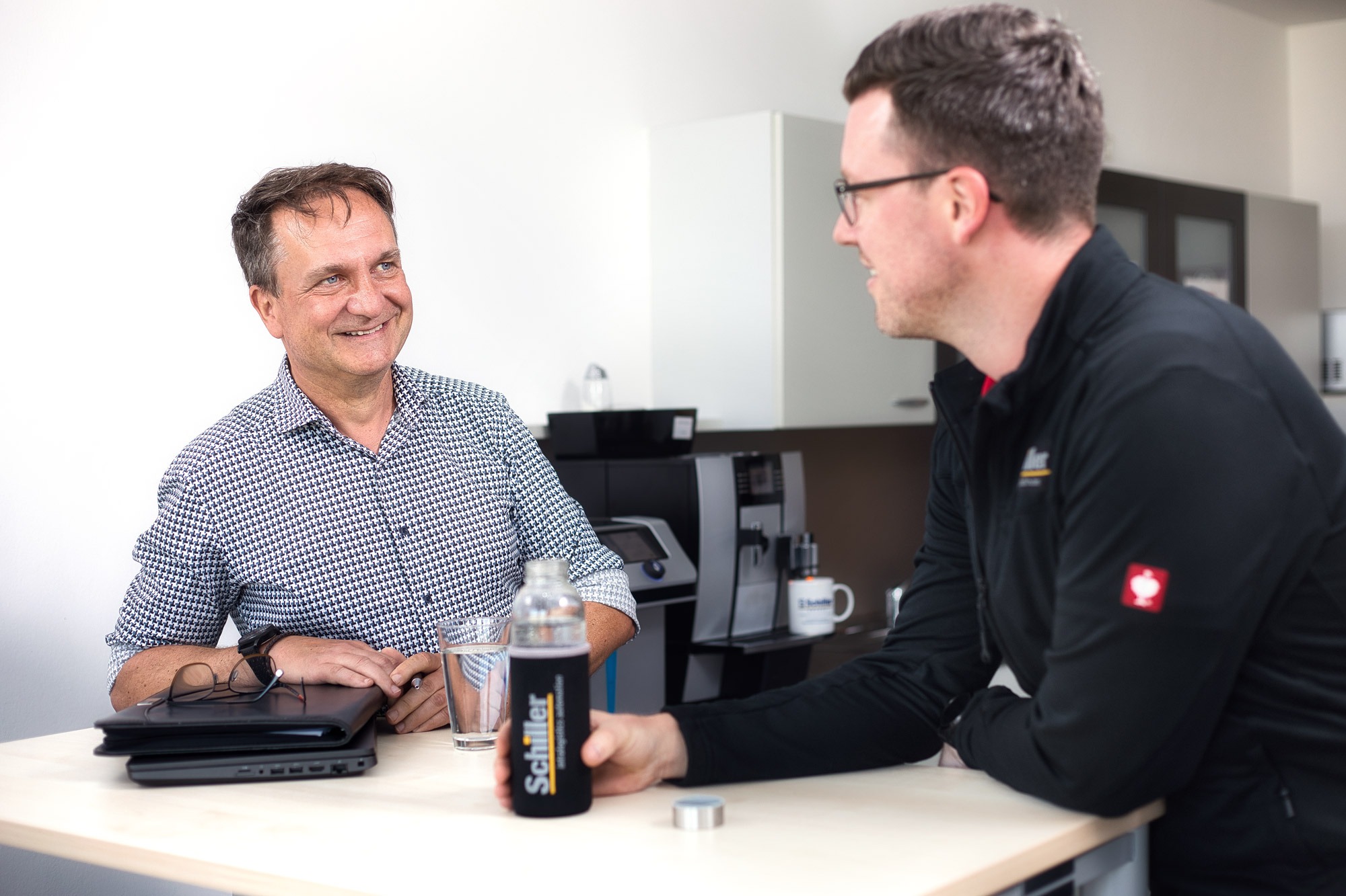 2 Mitarbeiter am kostenlosen Wasserspender bei Schiller